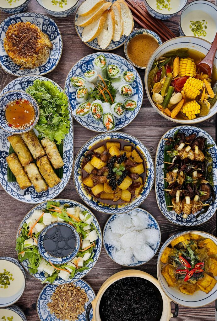 An overhead shot of a vibrant Vietnamese feast on beautifully patterned blue ceramic plates.